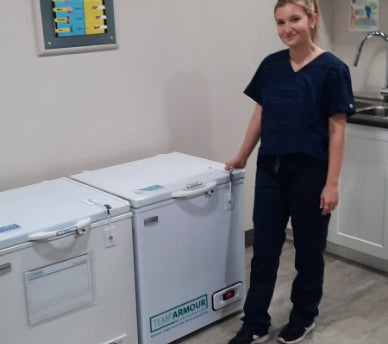 Nurse standing next to the TempArmour Vaccine Refrigerator (Model BFRV36)